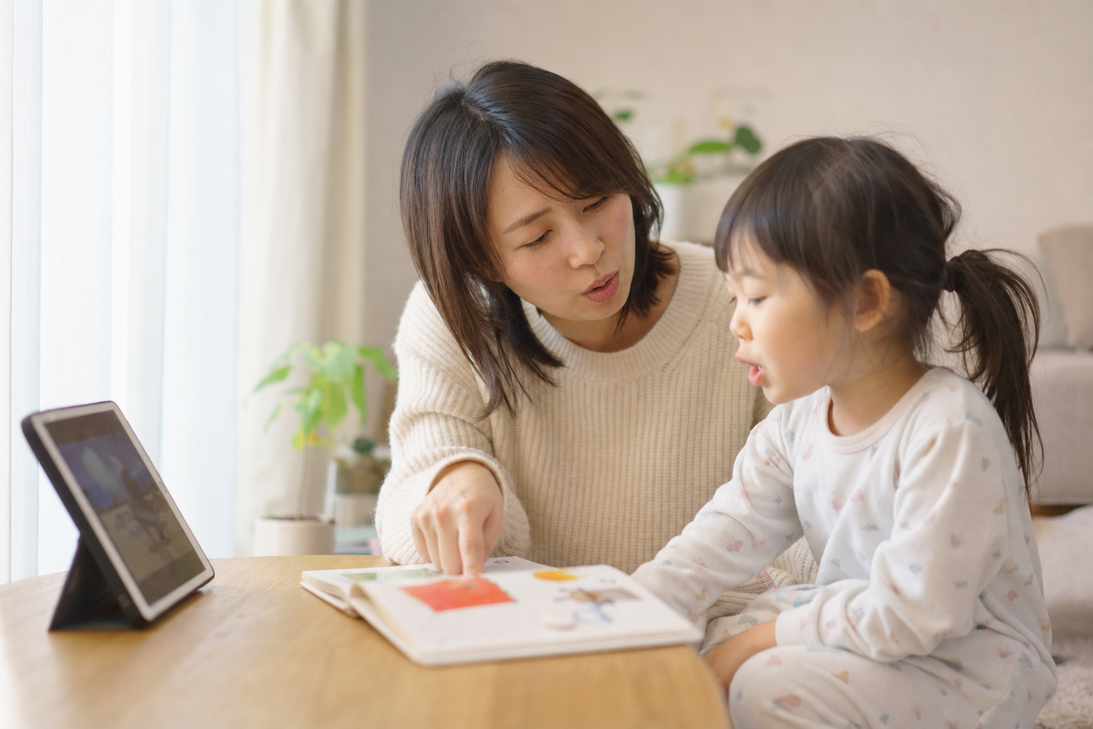 自宅で絵本を使って親子で英語を学ぶ様子